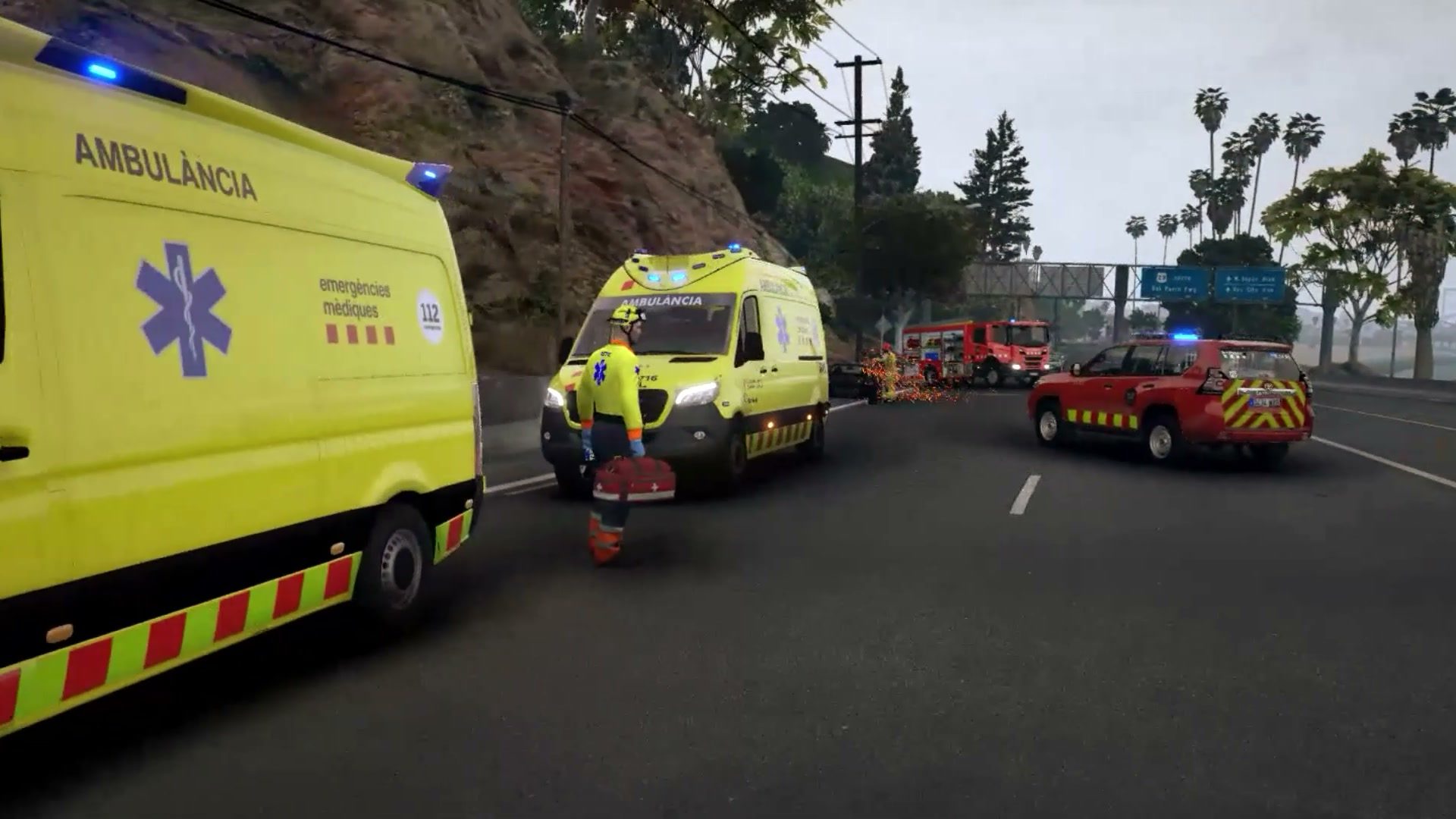 Técnico del SEM junto a la ambulancia mientras los Bombers terminan en la carretera