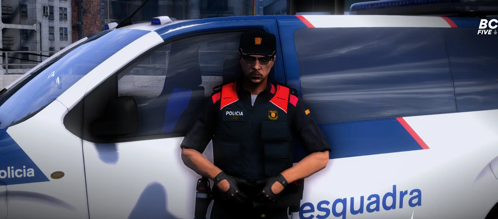 Agente de Mossos d’Esquadra con el chaleco reglamentario junto a un coche patrulla