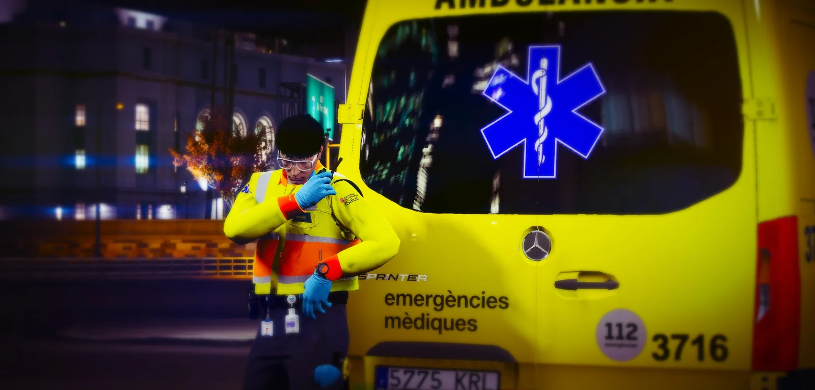Técnico del SEM junto a una ambulancia de noche con un incendio de fondo